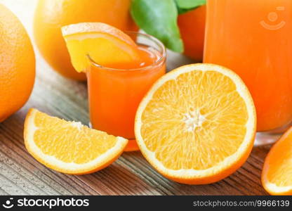 Fresh orange juice in the glass with orange fruit on wooden background, healthy fruits and orange slice 