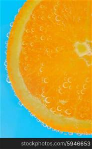 Fresh orange slice in water with bubbles