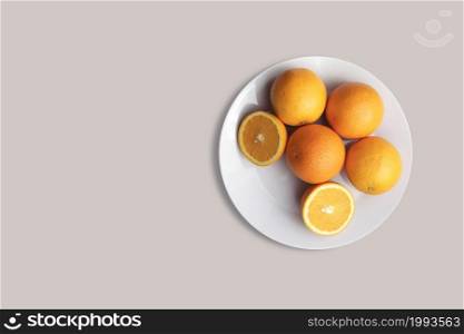 Fresh oranges fruit on a white plate for the menu. Geometric background. Flat lay, copy space, top view.