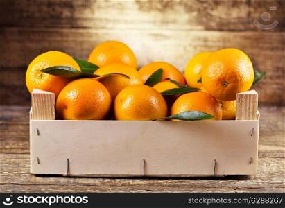 fresh oranges in wooden box on wooden background