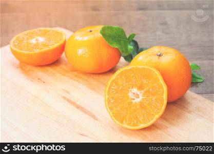 Fresh oranges on wooden table in kitchen with sunlight