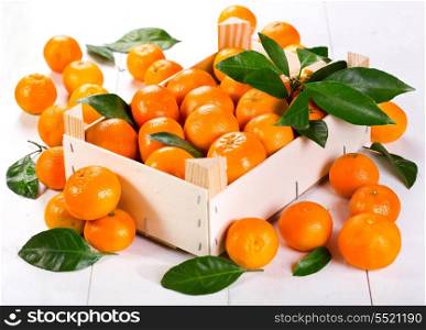 fresh oranges with leaves on wooden box