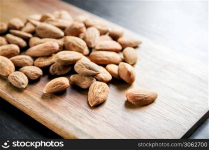 Fresh organic almonds on a wooden cutting board. Almonds on a wooden cutting board