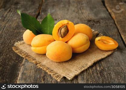 Fresh organic apricots with leaves on a wooden background