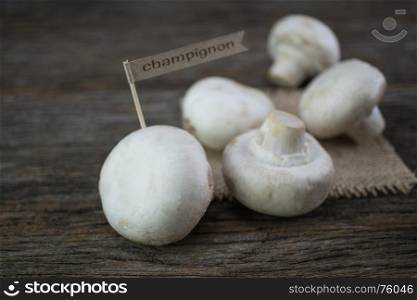 Fresh organic champignon mushrooms on wood background