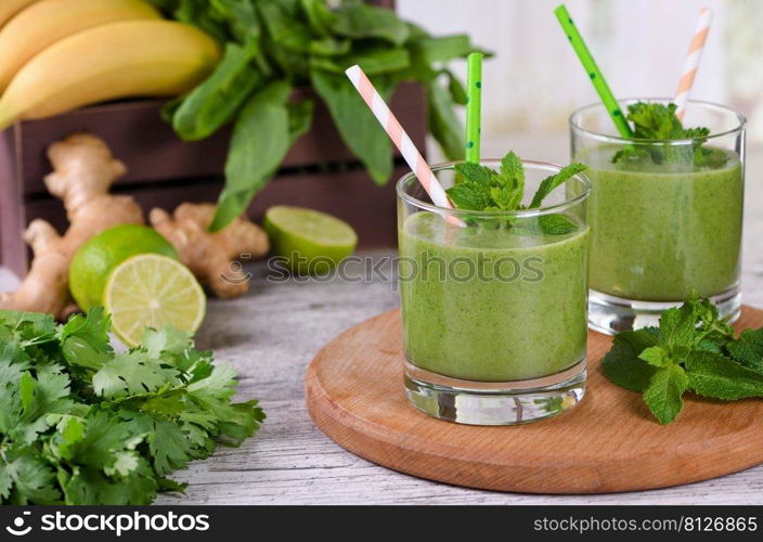 Fresh organic detox green drink smoothie with celery, spinach, banana, cilantro, lime and ginger with refreshing mint. Healthy, dietary, vegetarian food