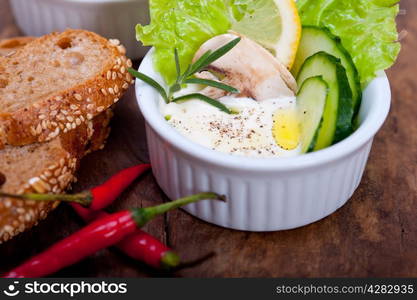 fresh organic garlic cheese dip salad on a rustic table with bread