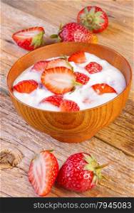 fresh organic greek yogurt with strawberries on wooden background