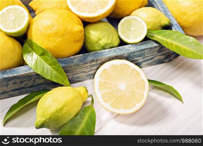 Fresh organic lemon fruits with leaves on wooden table