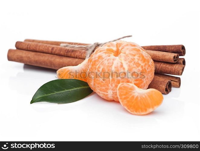 Fresh organic mandarin fruit with raw cinnamon on white background