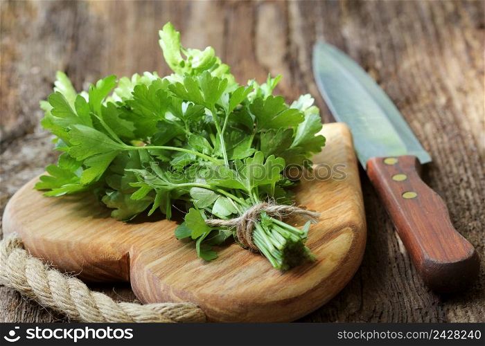 Fresh organic parsley with knife on wooden cutting board. Macro with shallow dof.. Fresh organic parsley with knife on wooden cutting board. Macro with shallow dof