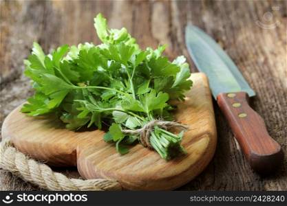 Fresh organic parsley with knife on wooden cutting board. Macro with shallow dof.. Fresh organic parsley with knife on wooden cutting board. Macro with shallow dof