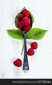 Fresh organic raspberry in a spoon. Wooden background