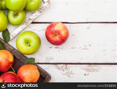 Fresh organic red and green apples in vintage box on wooden background.