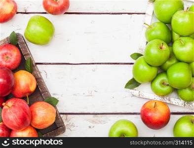 Fresh organic red and green apples in vintage box on wooden background.