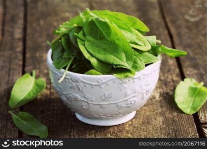 fresh organic sorrel leaves in bowl on wooden table .. fresh organic sorrel leaves in bowl on wooden table