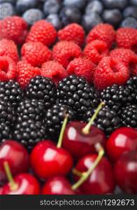 Fresh organic summer berries mix. Raspberries, strawberries, blueberries, blackberries and cherries.
