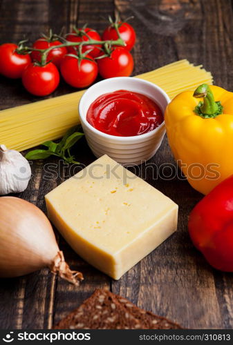 Fresh organic tomatoes with vegetables and spagetti on wooden board. Potatoes,sause,pepper,basil,spagetti