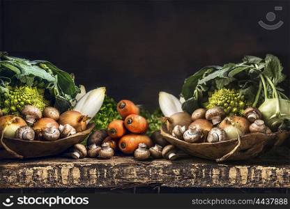 Fresh organic vegetables from garden on old rustic wooden table, vegetarian cooking concept