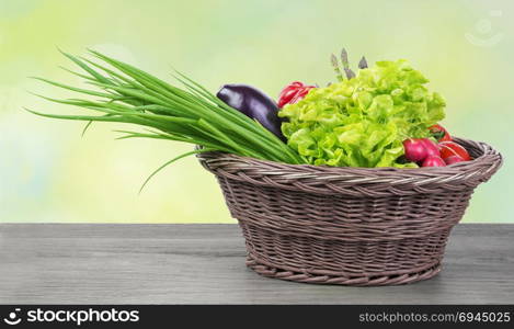 Fresh organic vegetables in a basket on wooden vintage table