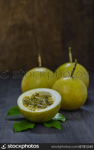 Fresh passion fruit and half over wooden background , still life