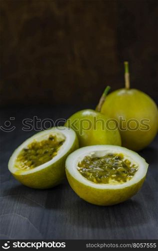 Fresh passion fruit juice in glass with passion fruits over wooden background , still life