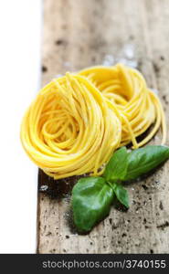 Fresh pasta and basil on wooden table