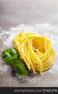 Fresh pasta and basil on wooden table