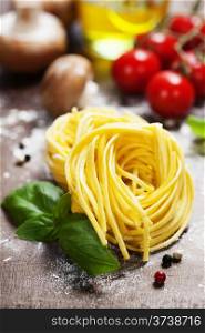 Fresh pasta and italian ingredients on wooden board