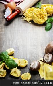 Fresh pasta and italian ingredients on wooden table
