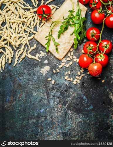 Fresh pasta with tomatoes,parmesan and arugula on rustic background, top view, border. Italian food concept.