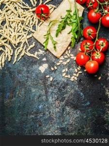 Fresh pasta with tomatoes,parmesan and arugula on rustic background, top view, border. Italian food concept.