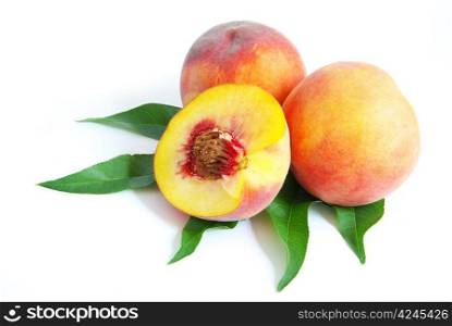 fresh peach fruits with green leaves isolated on white