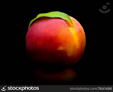 Fresh peach isolated. Organic nectarine or peach with green leaf on black background. Cut out with clipping path. Fresh peach isolated on white