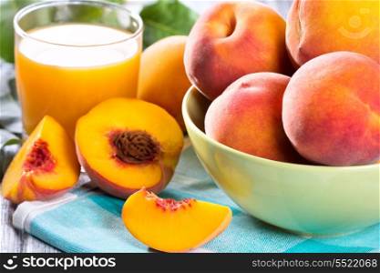 fresh peaches and glass of juice on wooden table