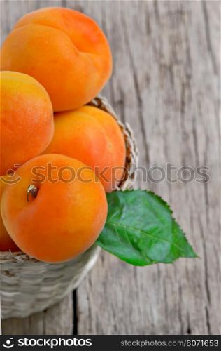 Fresh peaches in the basket on a wooden table