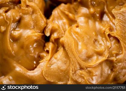 Fresh peanut butter. Macro background. The texture of peanut butter. High quality photo. Fresh peanut butter. Macro background.