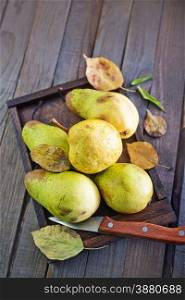 fresh pear on wooden tray and on a table