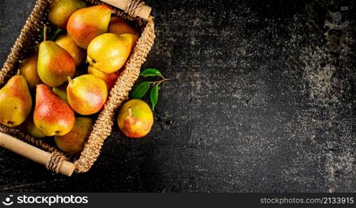 Fresh pears in a basket. On a black background. High quality photo. Fresh pears in a basket.