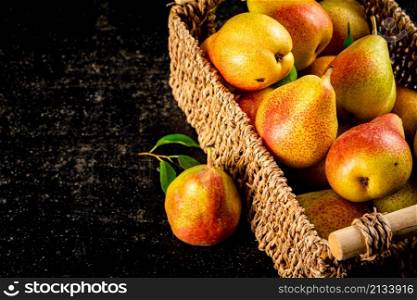 Fresh pears in a basket. On a black background. High quality photo. Fresh pears in a basket.