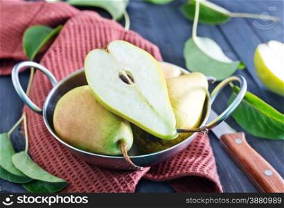 fresh pears in bowl and on a table