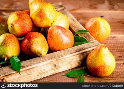 Fresh pears on a tray with leaves. On a wooden background. High quality photo. Fresh pears on a tray with leaves.