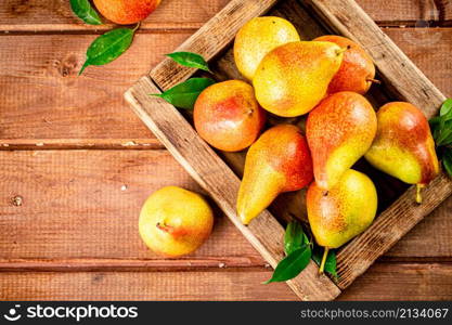 Fresh pears on a tray with leaves. On a wooden background. High quality photo. Fresh pears on a tray with leaves.