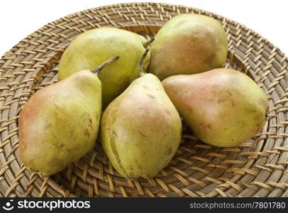 Fresh pears on wicker plate on white