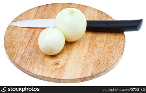 fresh peeled onion bulbs with ceramic knife on wooden cutting board isolated on white background