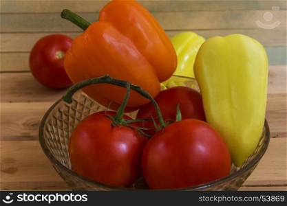 Fresh peppers and tomatoes in a glass vase
