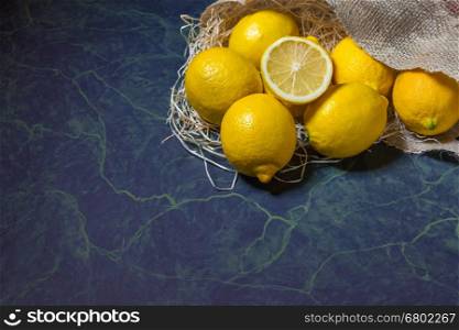 Fresh picked lemons spilling from a burlap sack. Horizontal format with copy space.