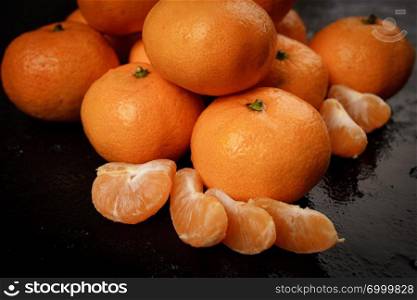 Fresh picked mandarins on black background