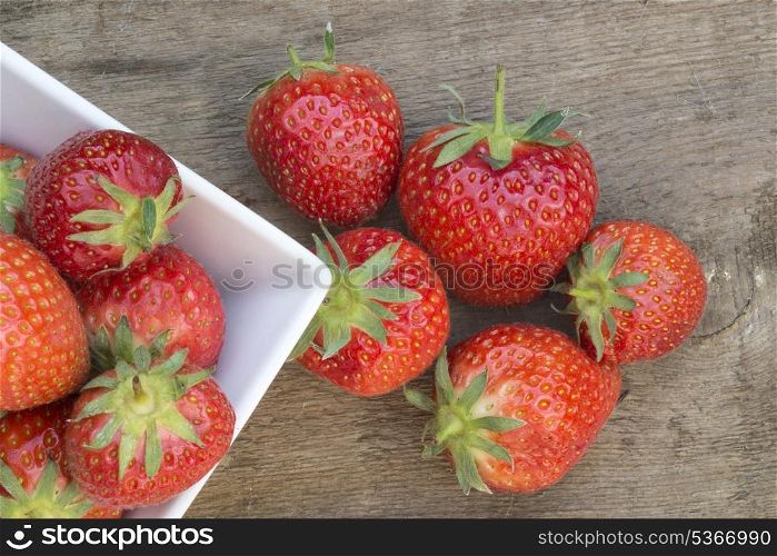Fresh picked Summer strawberries on rustic wooden background. Macro shot of fresh Summer strawberries