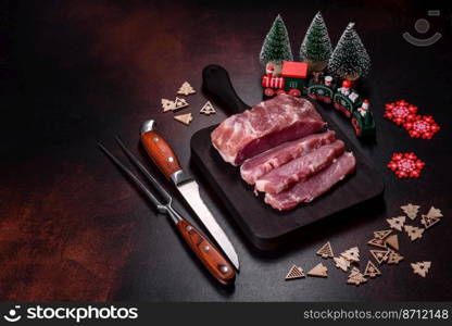 Fresh piece of raw pork with spices, salt and herbs on a wooden cutting board. Cooking grilled meals at home. Fresh piece of raw pork with spices, salt and herbs on a wooden cutting board